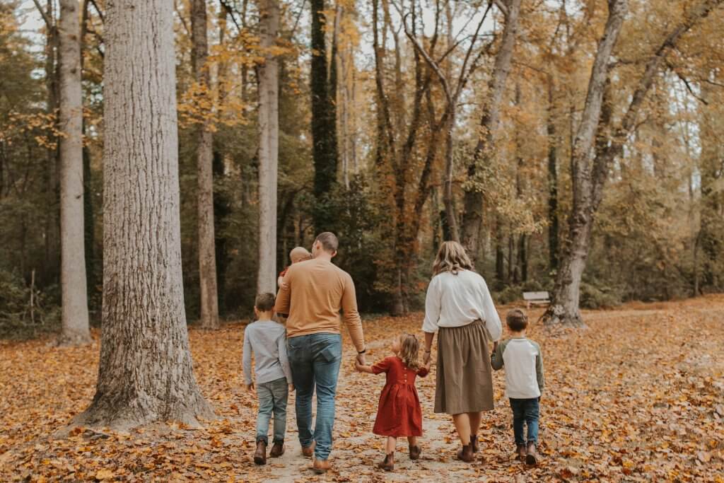 Family walking through the leaves holding hands for Family Pictures