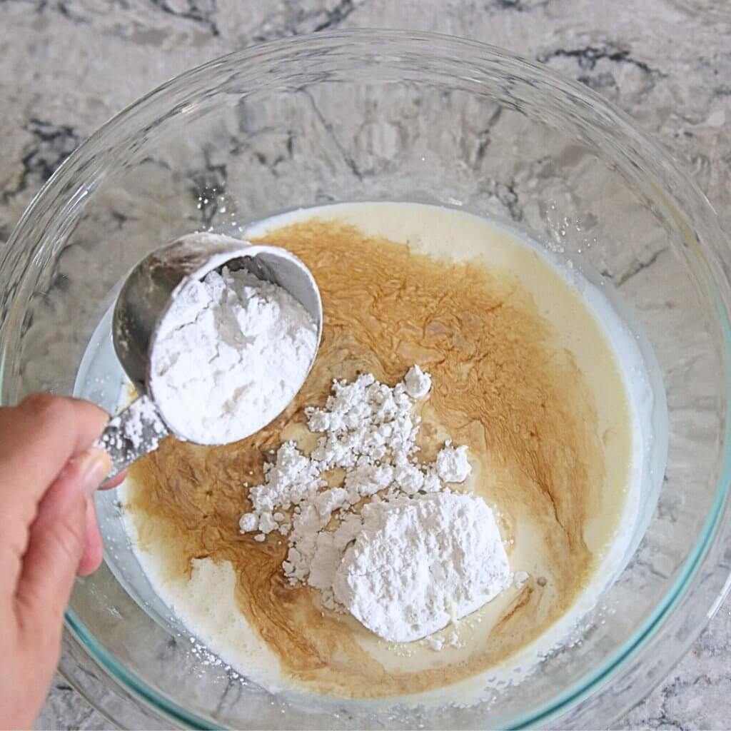 Whipped Cream with powdered sugar being added to bowl