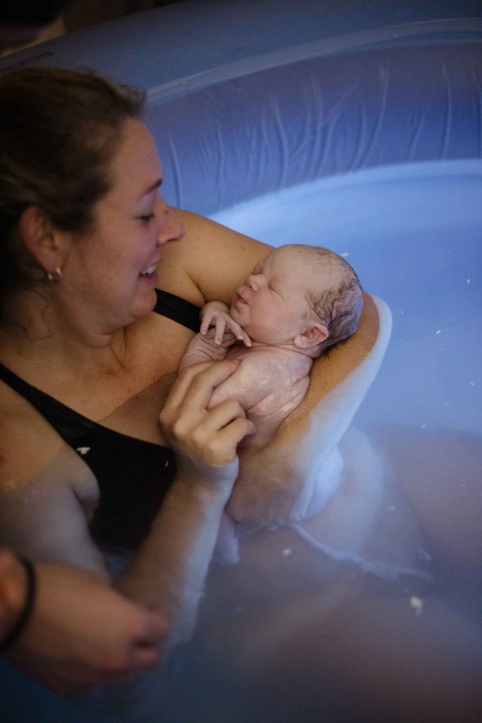 Woman in birth tub with new baby