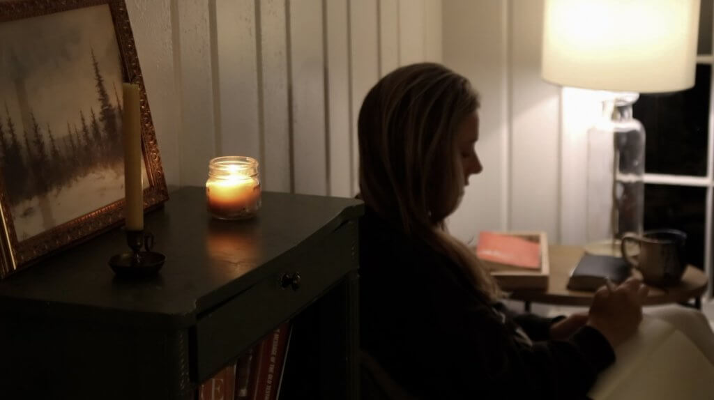 Woman journaling by candle light