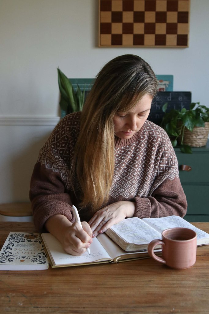 woman journaling at a table with coffee mug