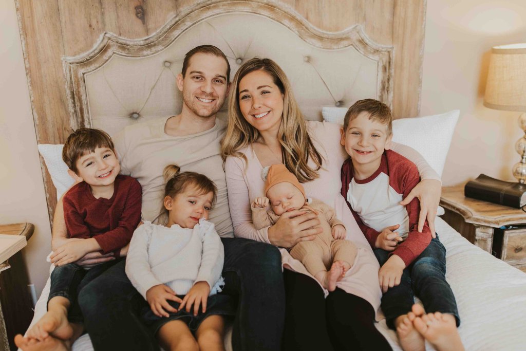 family smiling together on the bed